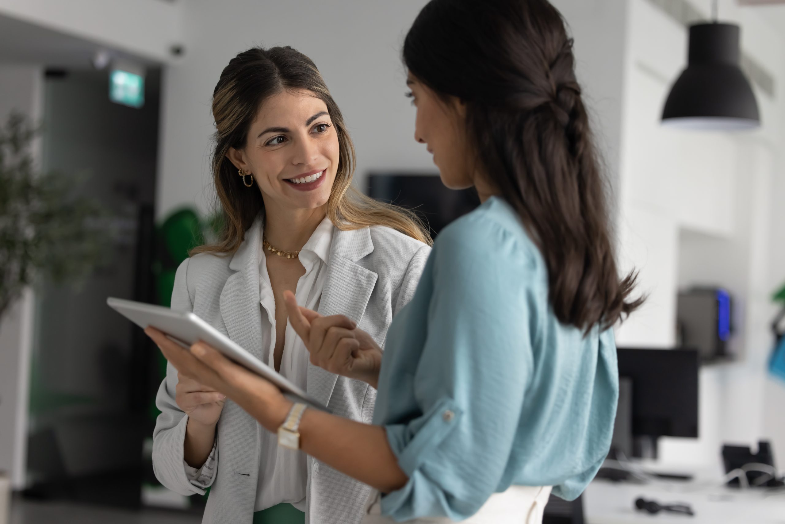 Young,Businesswoman,Listening,To,Experienced,Coworker,With,Digital,Tablet,Receiving